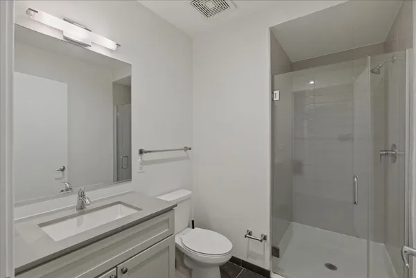 a bathroom with a granite countertop sink a toilet and shower
