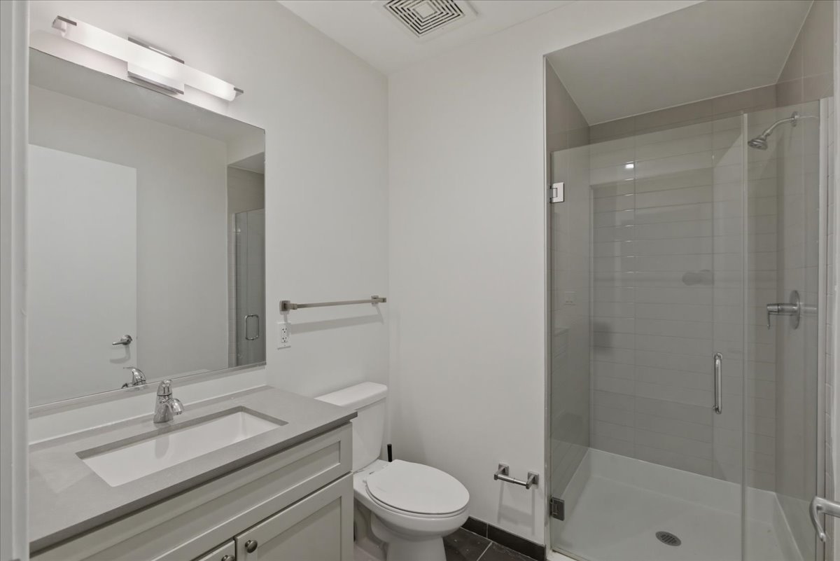 830 North Milwaukee Avenue, Unit 506 Chicago, IL 60642 - Photo 11 of 15 a bathroom with a granite countertop sink a toilet and shower
