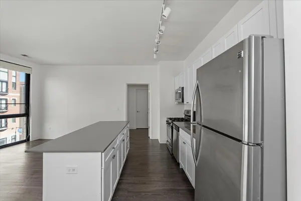 a kitchen with a refrigerator a sink and wooden floor