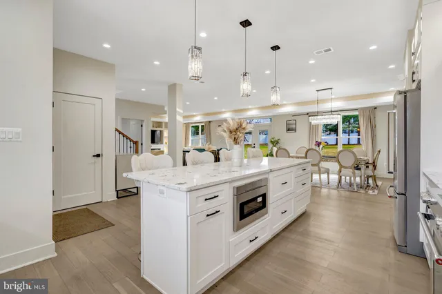 a large white kitchen with lots of counter space and stainless steel appliances