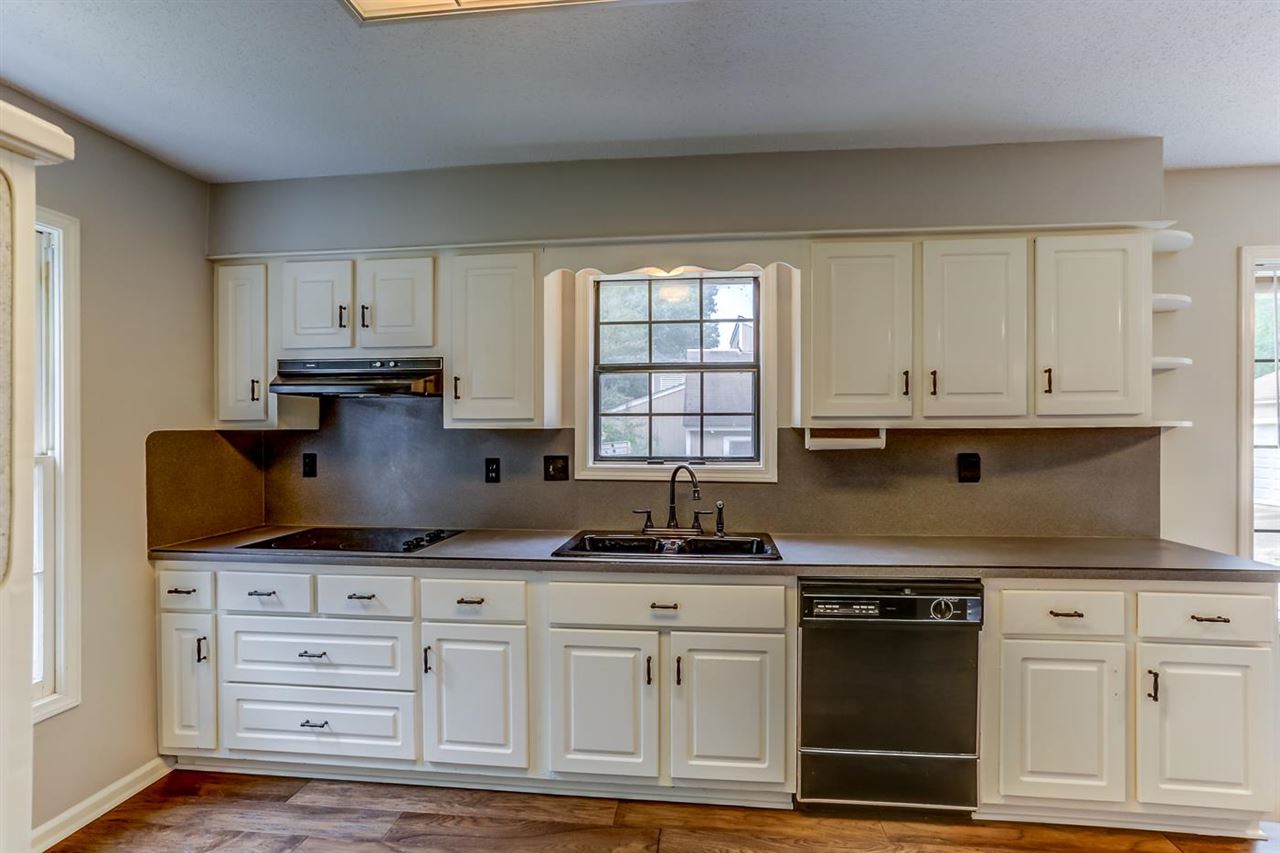 445 Dove Valley Road Collierville, TN 38017 - Photo 12 of 24 a kitchen with granite countertop a stove a sink and white cabinets