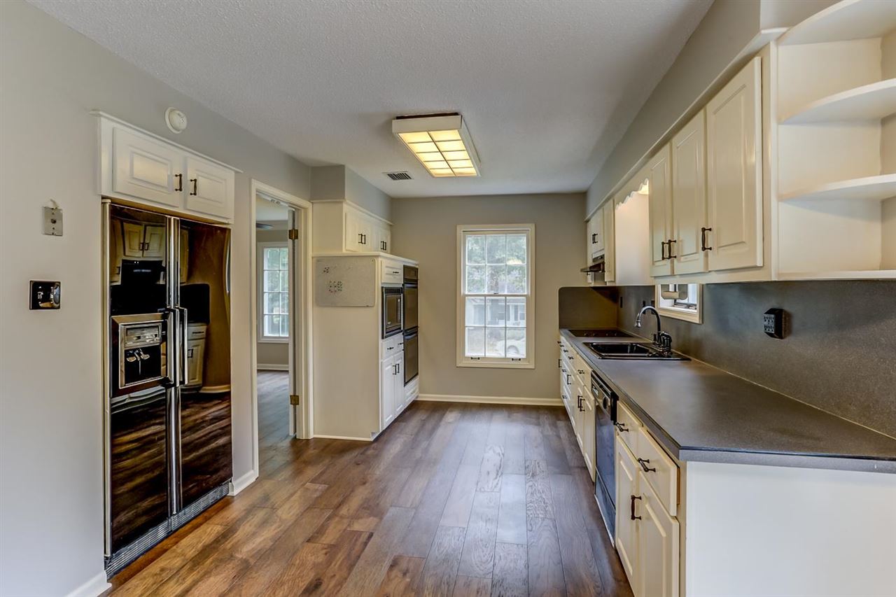 445 Dove Valley Road Collierville, TN 38017 - Photo 3 of 24 a kitchen with granite countertop a refrigerator and a stove top oven