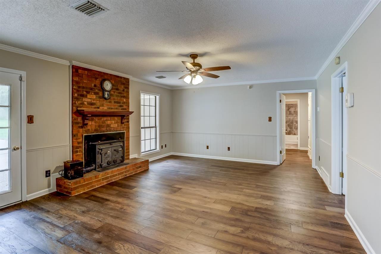 445 Dove Valley Road Collierville, TN 38017 - Photo 7 of 24 an empty room with windows fireplace and a ceiling fan