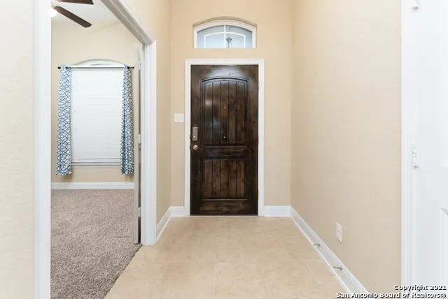 an empty room with chandelier fan