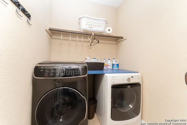a view of an empty room with a kitchen and a window