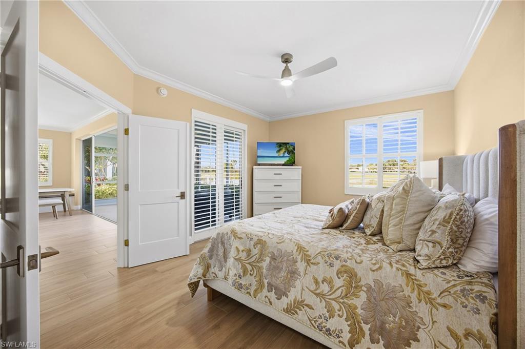 23151 Rosedale Drive, Unit 101 Estero, FL 34135 - Photo 11 of 20 Bedroom with access to outside, crown molding, new flooring, and ceiling fan. New king bed, dresser, night stand, lamp and TV can be included.