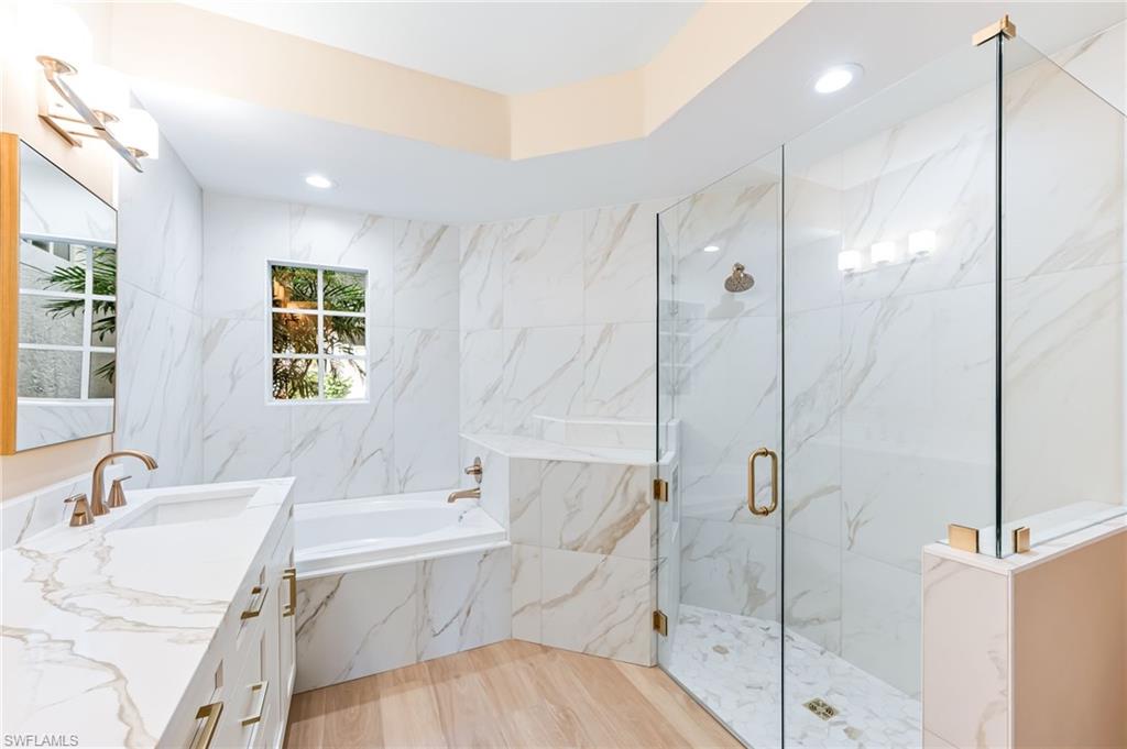 23151 Rosedale Drive, Unit 101 Estero, FL 34135 - Photo 14 of 20 Primary bath with quartz countertops and frameless shower enclosure.