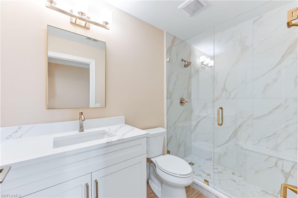 23151 Rosedale Drive, Unit 101 Estero, FL 34135 - Photo 16 of 20 Second bath with new quartz countertop, cabinet, mirror, lighting, and frameless glass shower area.