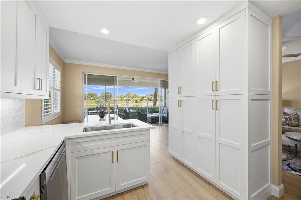 23151 Rosedale Drive, Unit 101 Estero, FL 34135 - Photo 6 of 20 Kitchen featuring new white cabinetry, a peninsula, light quartz counters, crown molding, and recessed lighting