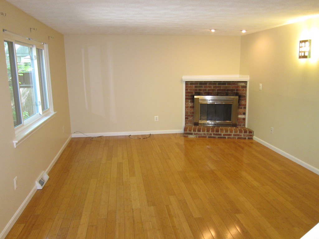 47 Mountain Gate Road, Unit 47 Ashland, MA 01721 - Photo 3 of 15 a view of an empty room with a fireplace and a window