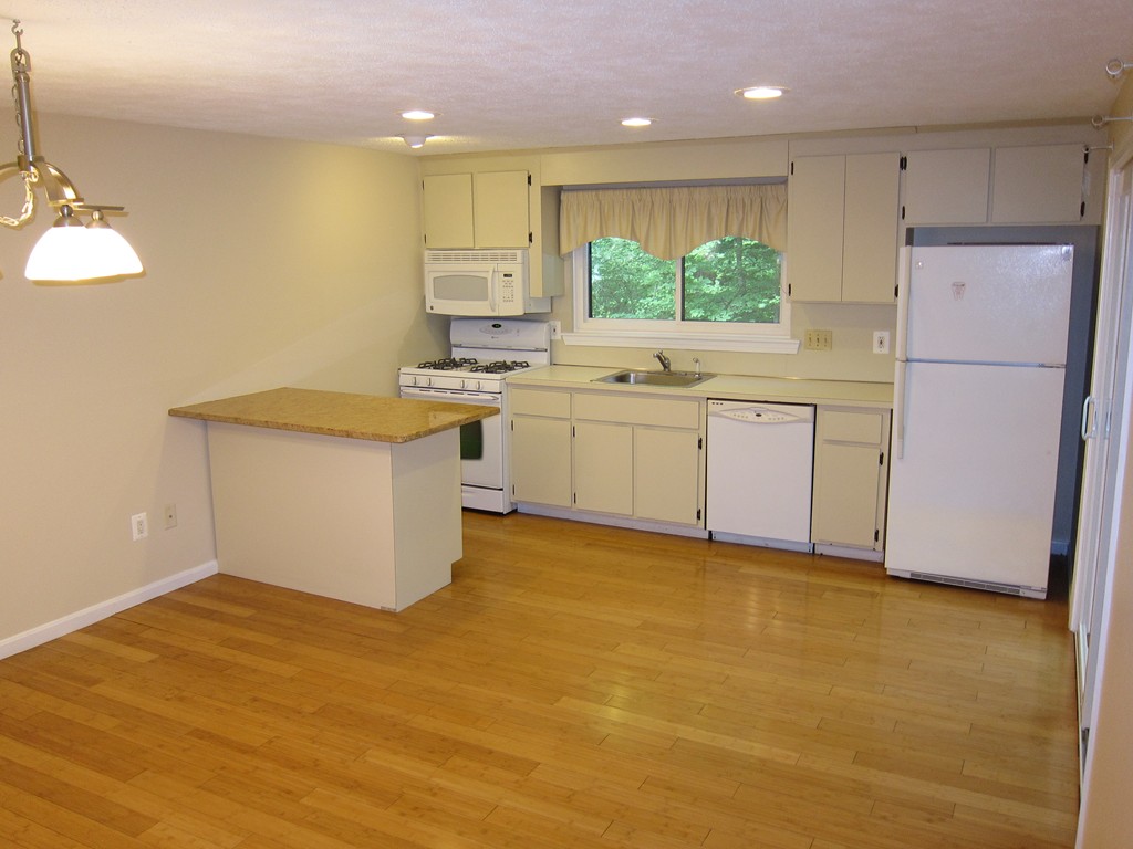47 Mountain Gate Road, Unit 47 Ashland, MA 01721 - Photo 5 of 15 a kitchen with stainless steel appliances granite countertop a sink a stove a refrigerator with white cabinets and wooden floor