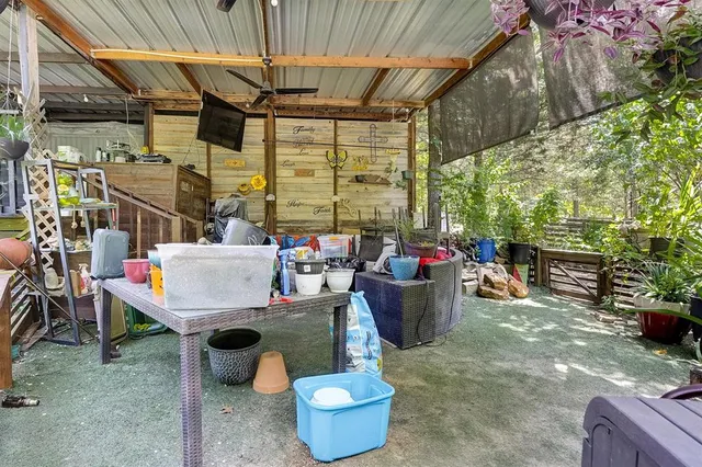 a view of a patio with table and chairs potted plants and large tree