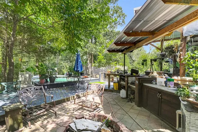 a view of a patio with table and chairs under an umbrella