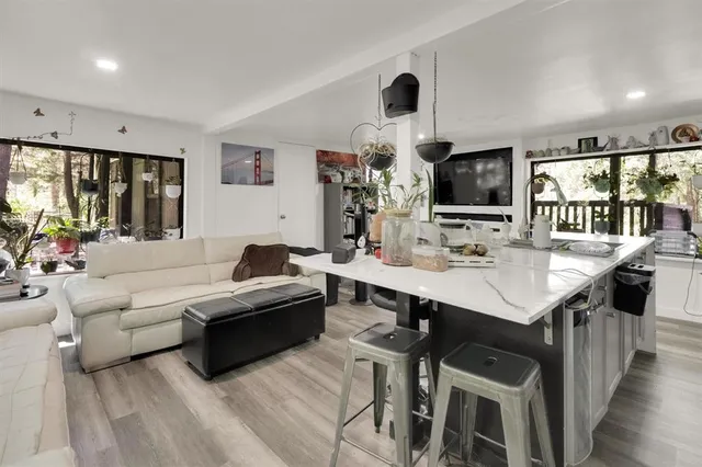 a living room with furniture a flat screen tv and a large window