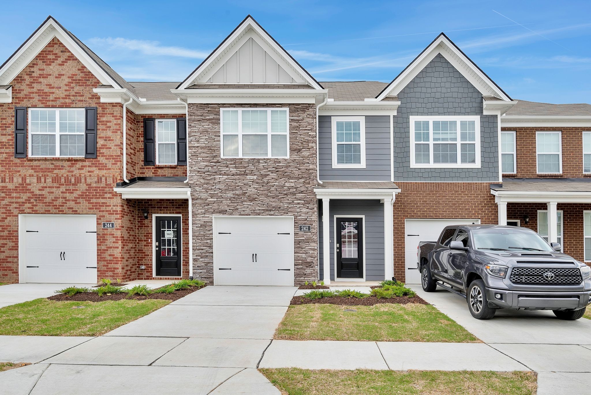 a car parked in front of a brick house with a yard
