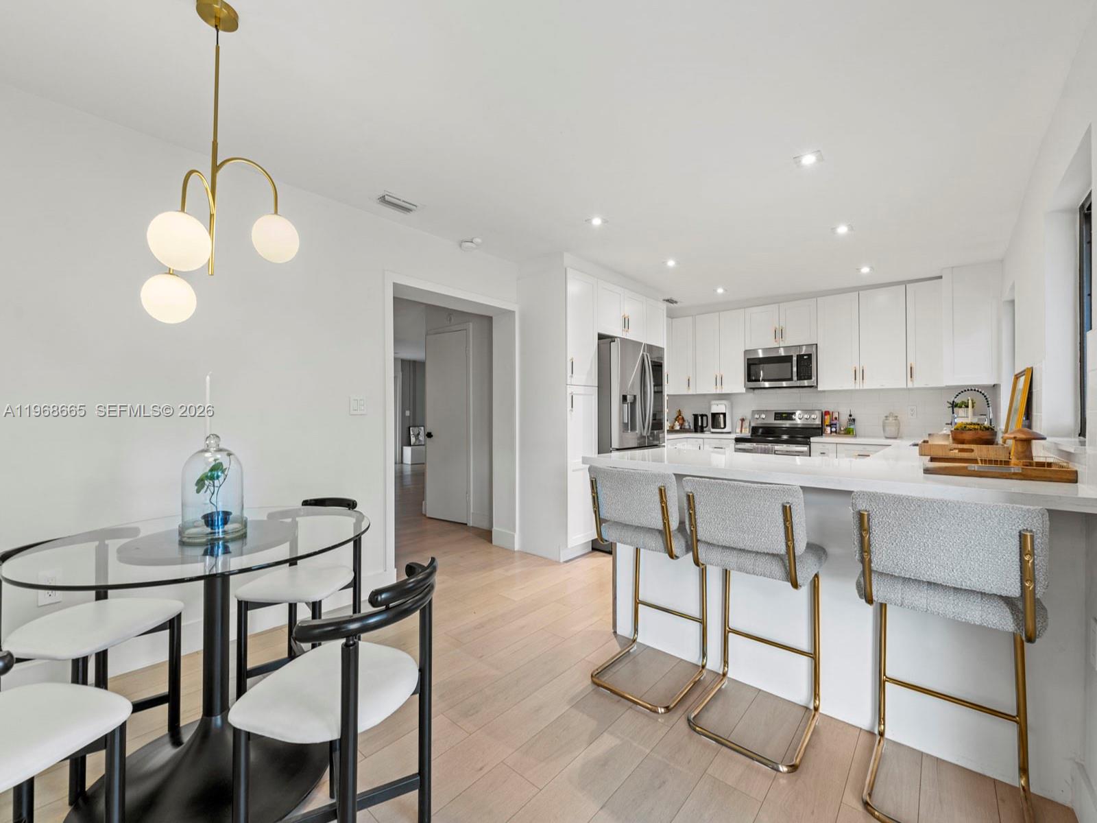 7731 Southwest 18th Terrace Miami, FL 33155 - Photo 17 of 50 a kitchen with stainless steel appliances kitchen island granite countertop a table chairs and a refrigerator