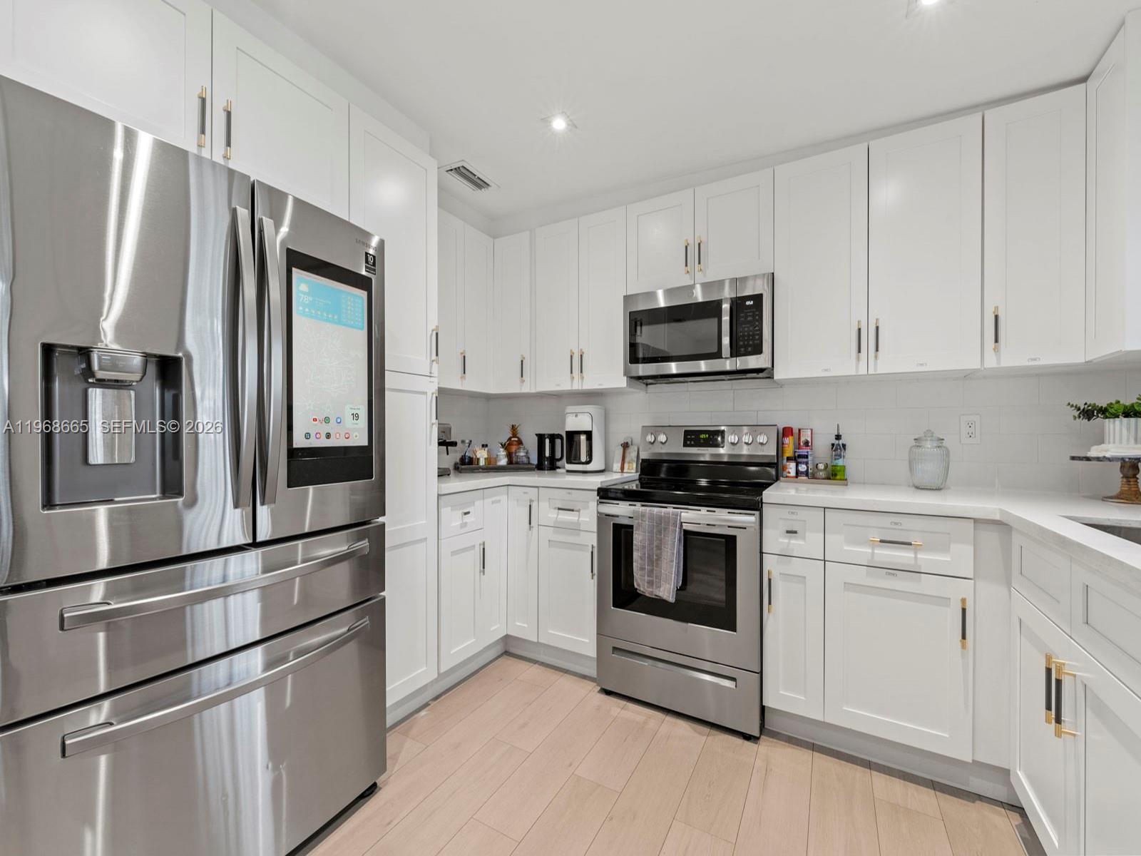 7731 Southwest 18th Terrace Miami, FL 33155 - Photo 20 of 50 a kitchen with stainless steel appliances and white cabinets