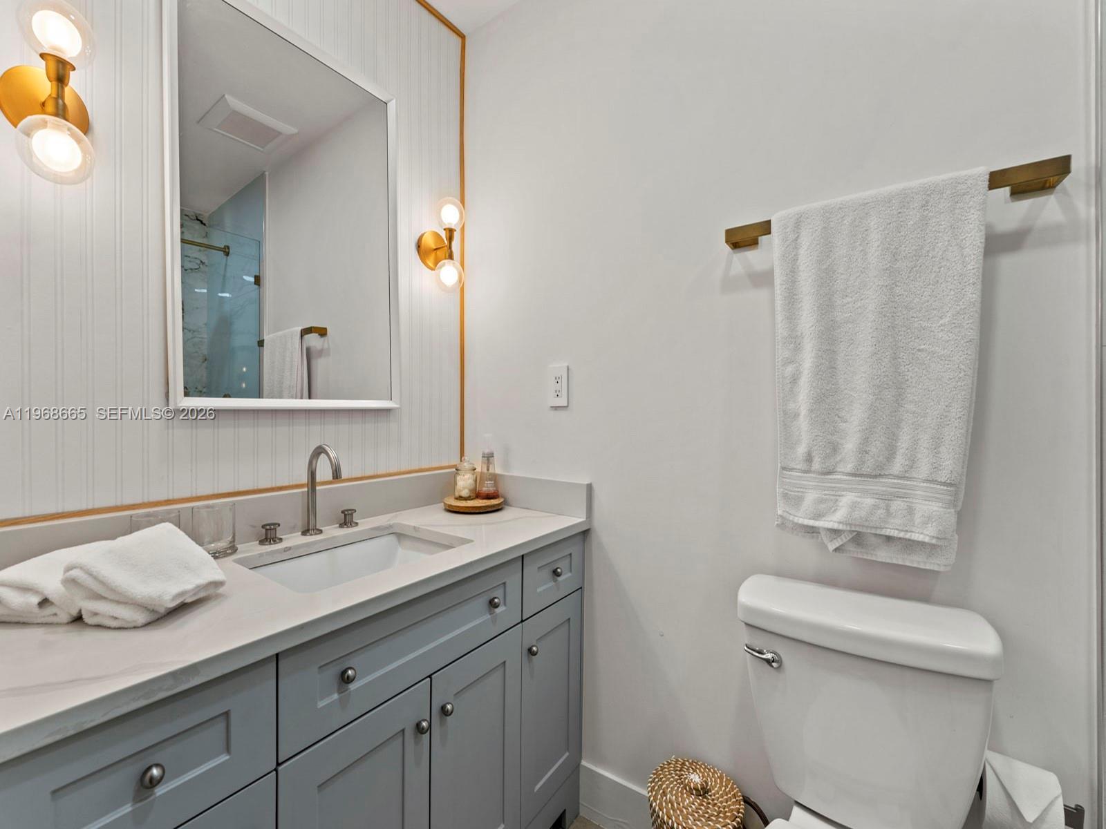 7731 Southwest 18th Terrace Miami, FL 33155 - Photo 30 of 50 a bathroom with a granite countertop sink a toilet and a mirror