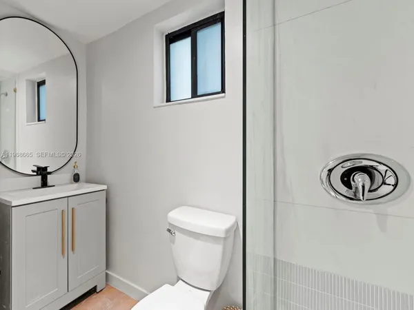 a bathroom with a toilet a sink and mirror