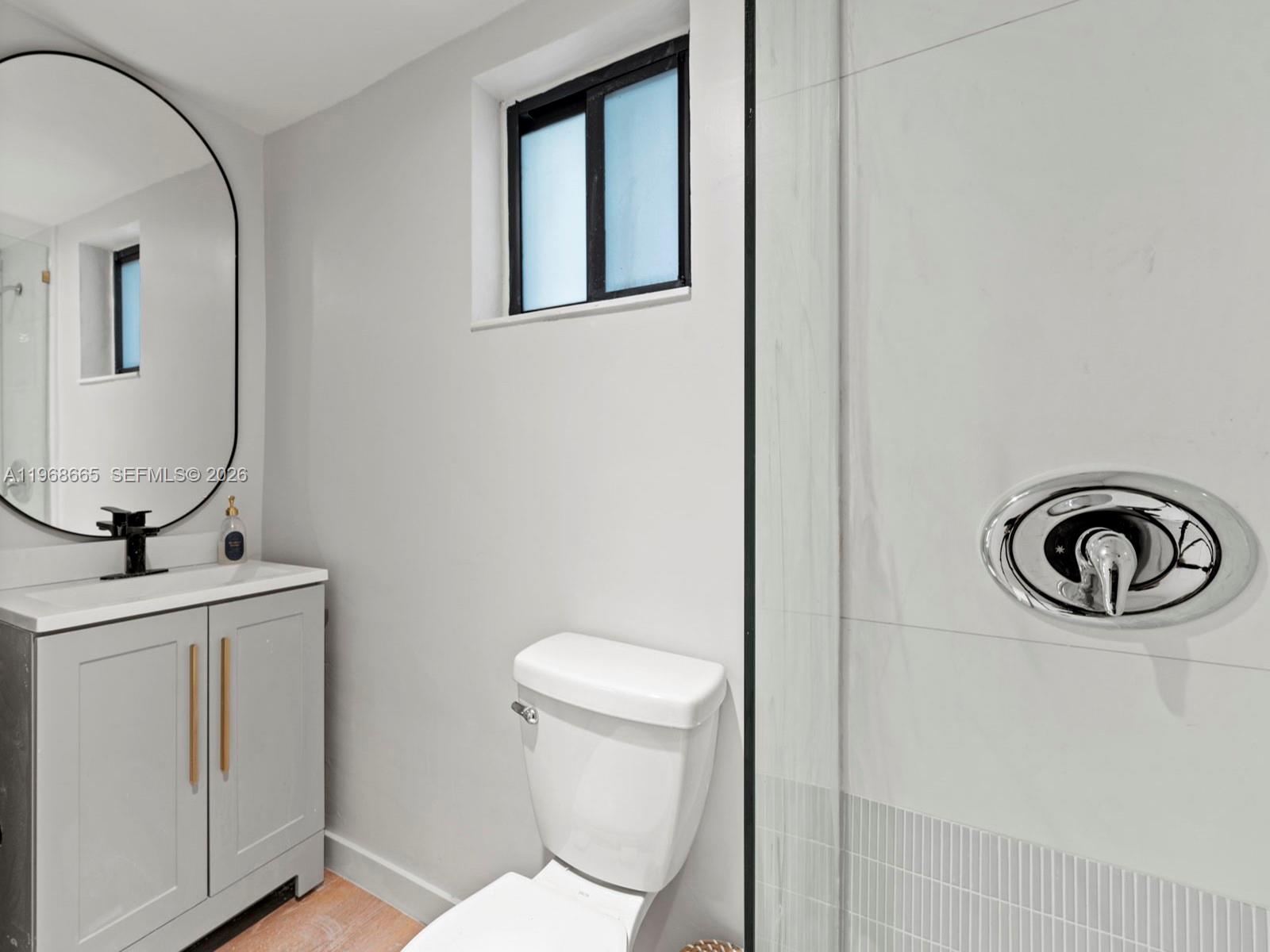 7731 Southwest 18th Terrace Miami, FL 33155 - Photo 35 of 50 a bathroom with a toilet a sink and mirror
