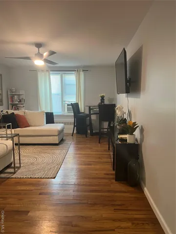 a view of kitchen and empty room with wooden floor