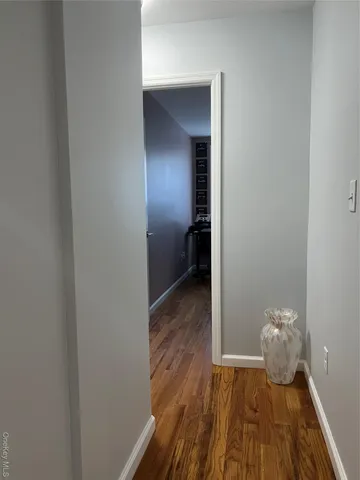 a view of a small space with wooden floor and a window