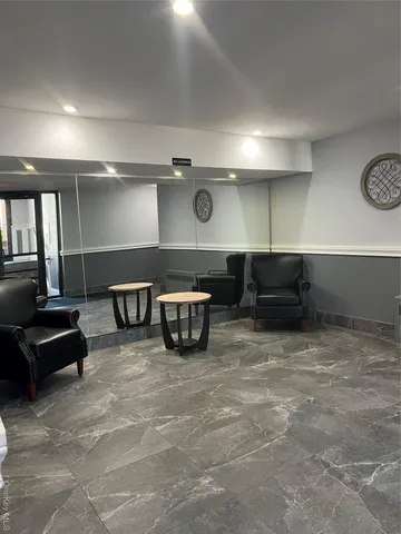 a view of an empty room with wooden floor and bench