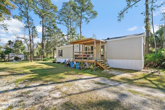 a view of a house with backyard and sitting area