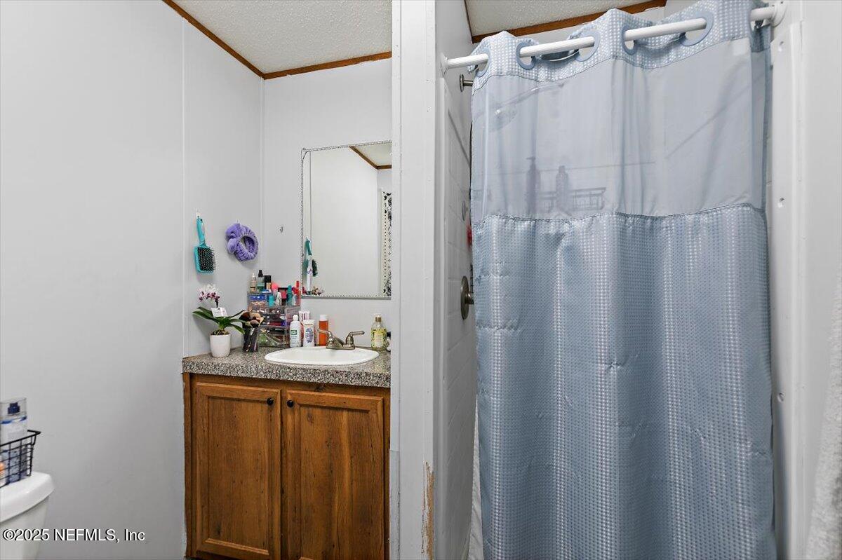 2670 Pleasure Lane St. Augustine, FL 32084 - Photo 7 of 12 a bathroom with a sink vanity mirror and shower