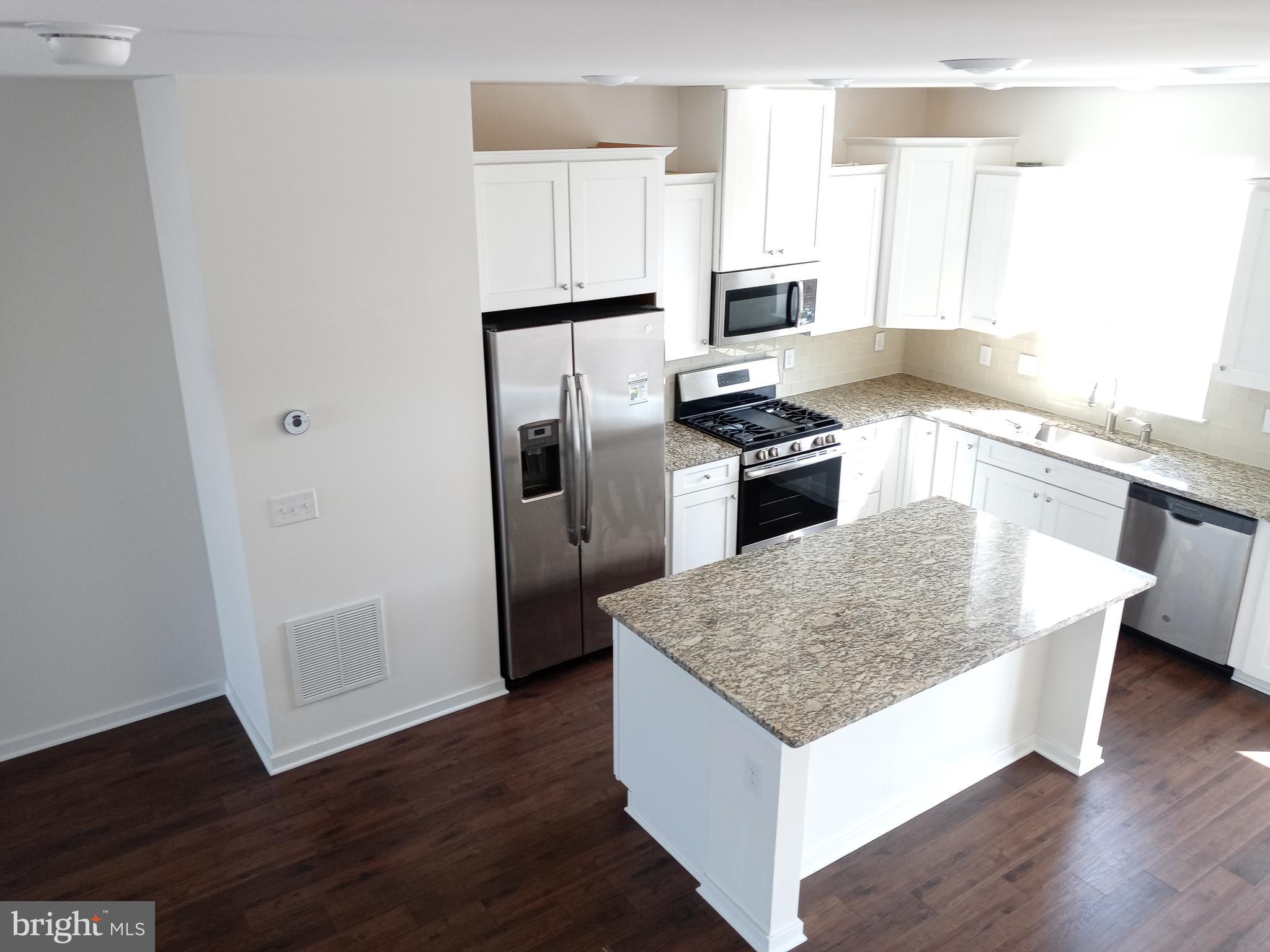 1908 Boulder Drive Downingtown, PA 19335 - Photo 12 of 27 a kitchen with stainless steel appliances granite countertop a refrigerator a sink dishwasher a stove and white countertops with wooden floor