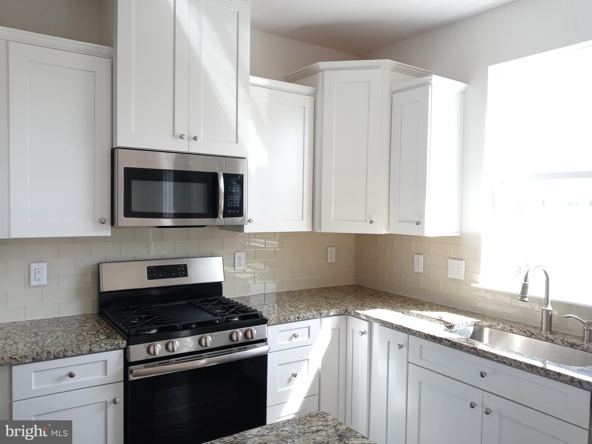 1908 Boulder Drive Downingtown, PA 19335 - Photo 13 of 27 a kitchen with granite countertop white cabinets and appliances