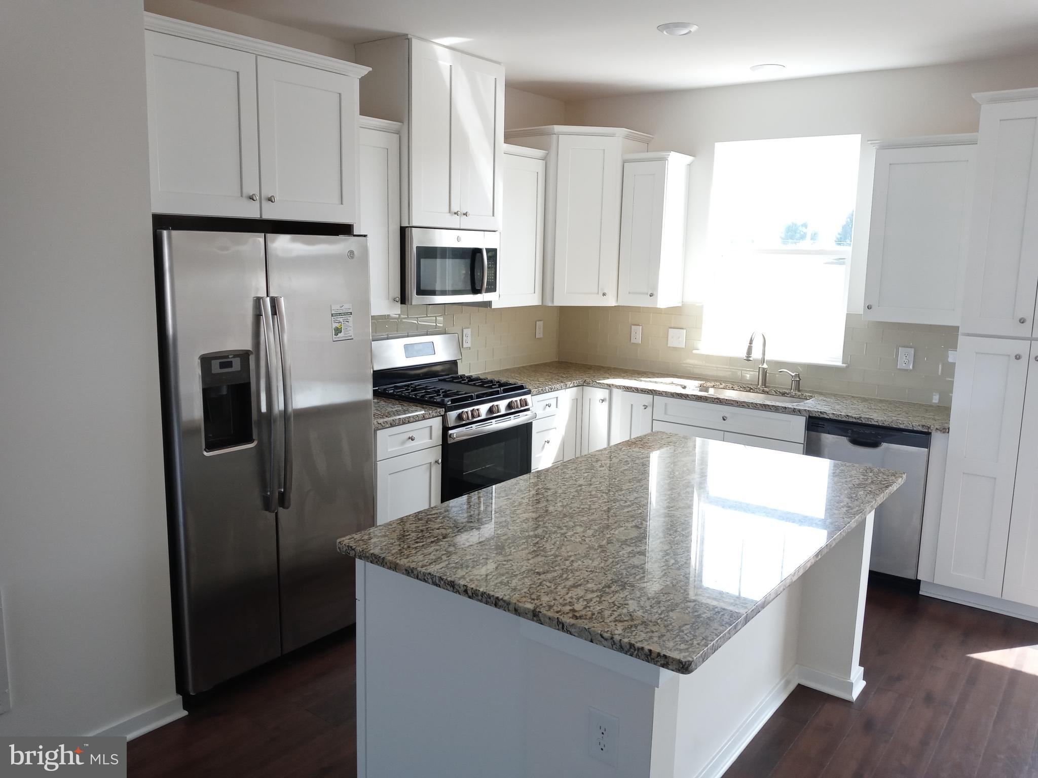 1908 Boulder Drive Downingtown, PA 19335 - Photo 9 of 27 a kitchen with stainless steel appliances granite countertop a sink a stove and refrigerator