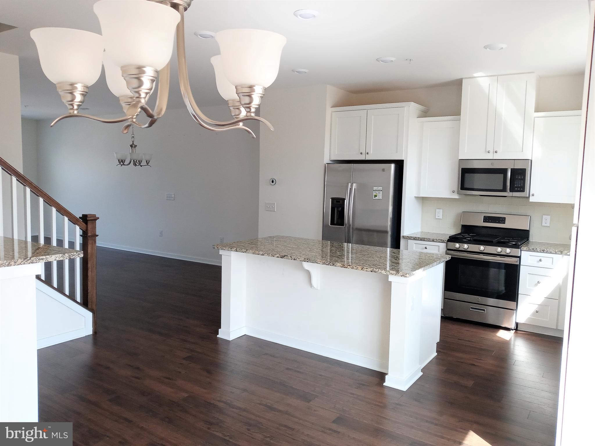 1908 Boulder Drive Downingtown, PA 19335 - Photo 10 of 27 a kitchen with stainless steel appliances a stove a microwave and a hard wood floor