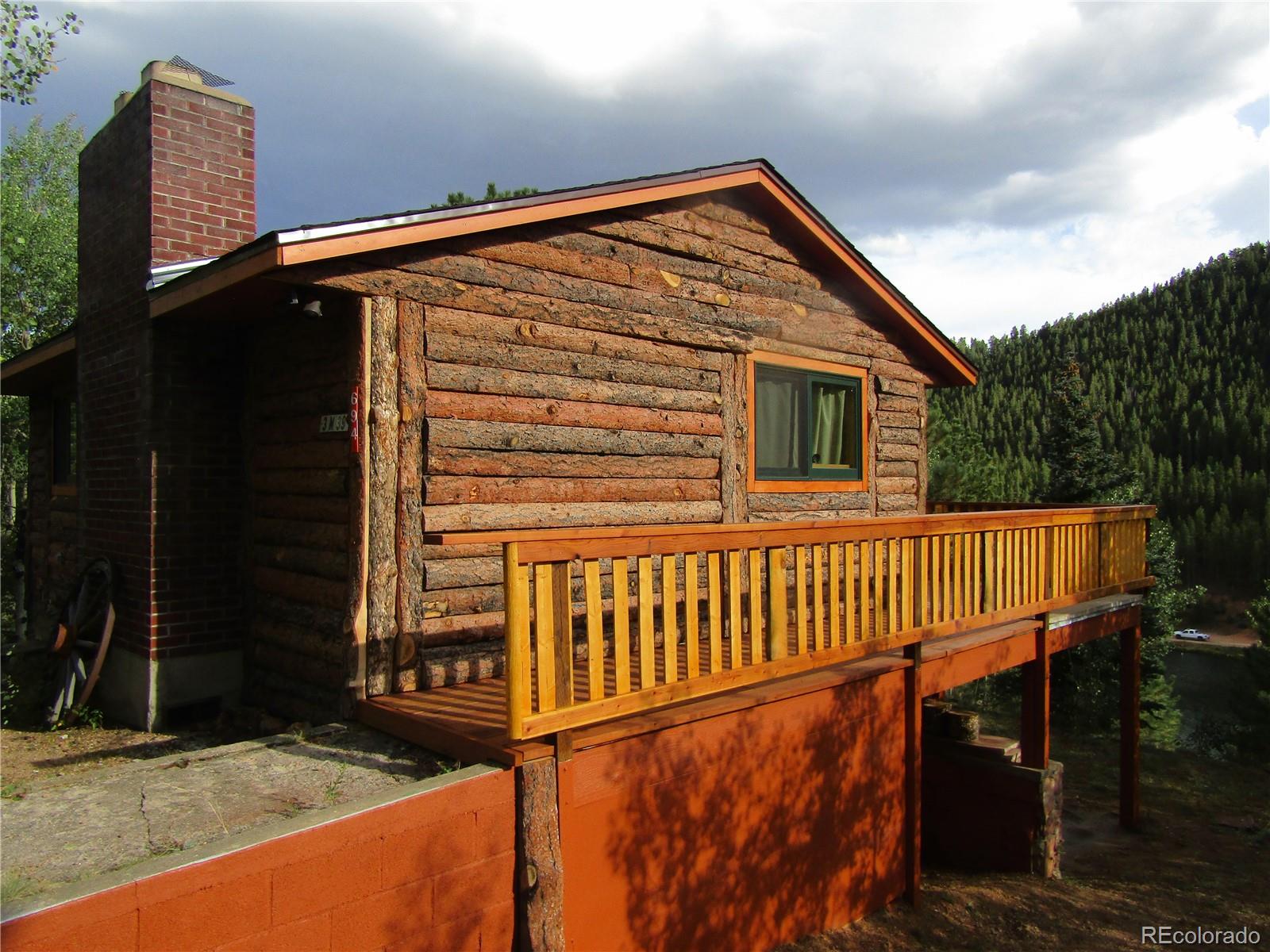 694 Gross Road Bailey, CO 80421 - Photo 2 of 24 a front view of a house with wooden floor and fence