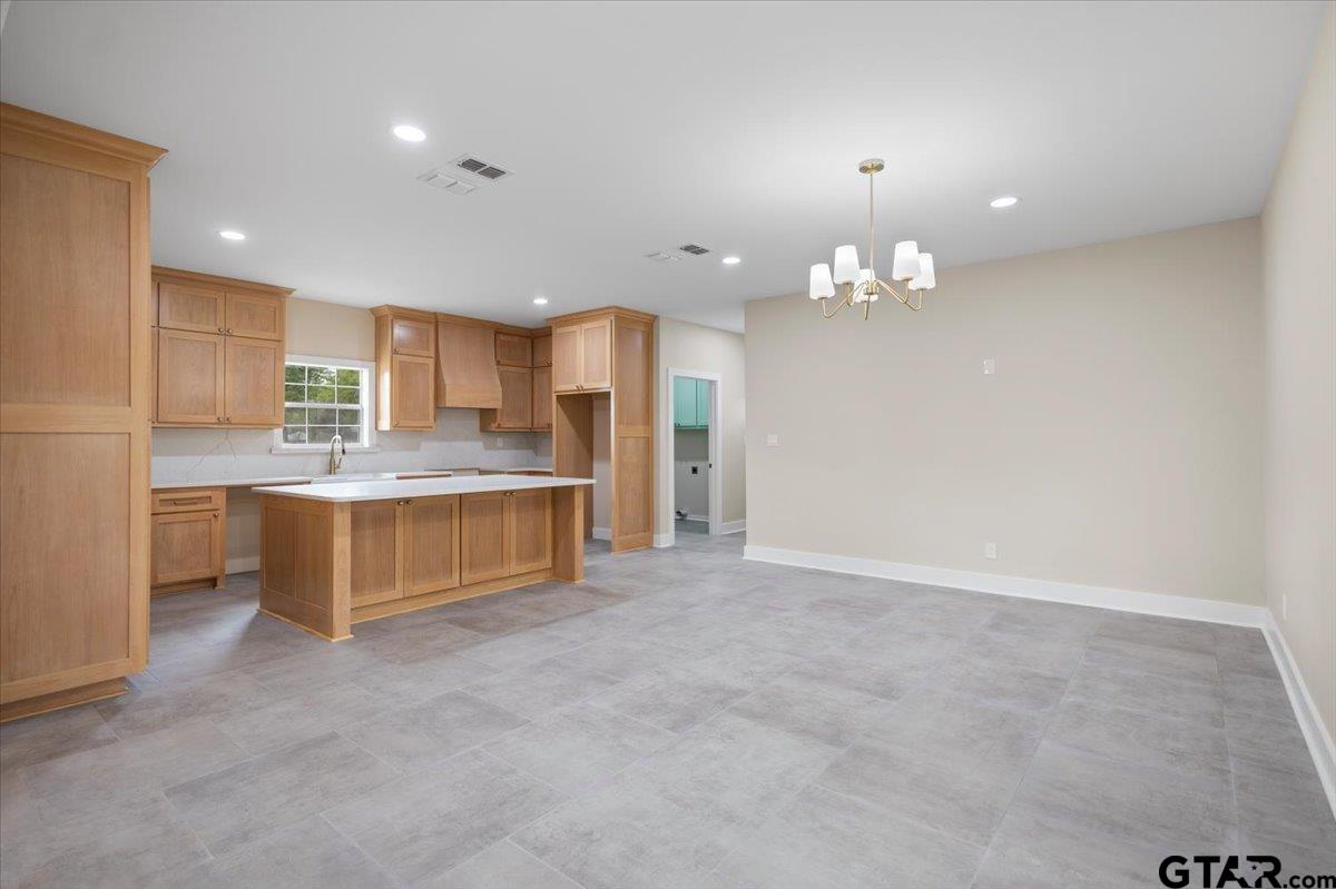 4123 County Road 1120 Tyler, TX 75704 - Photo 12 of 43 a large kitchen with a refrigerator and a stove top oven