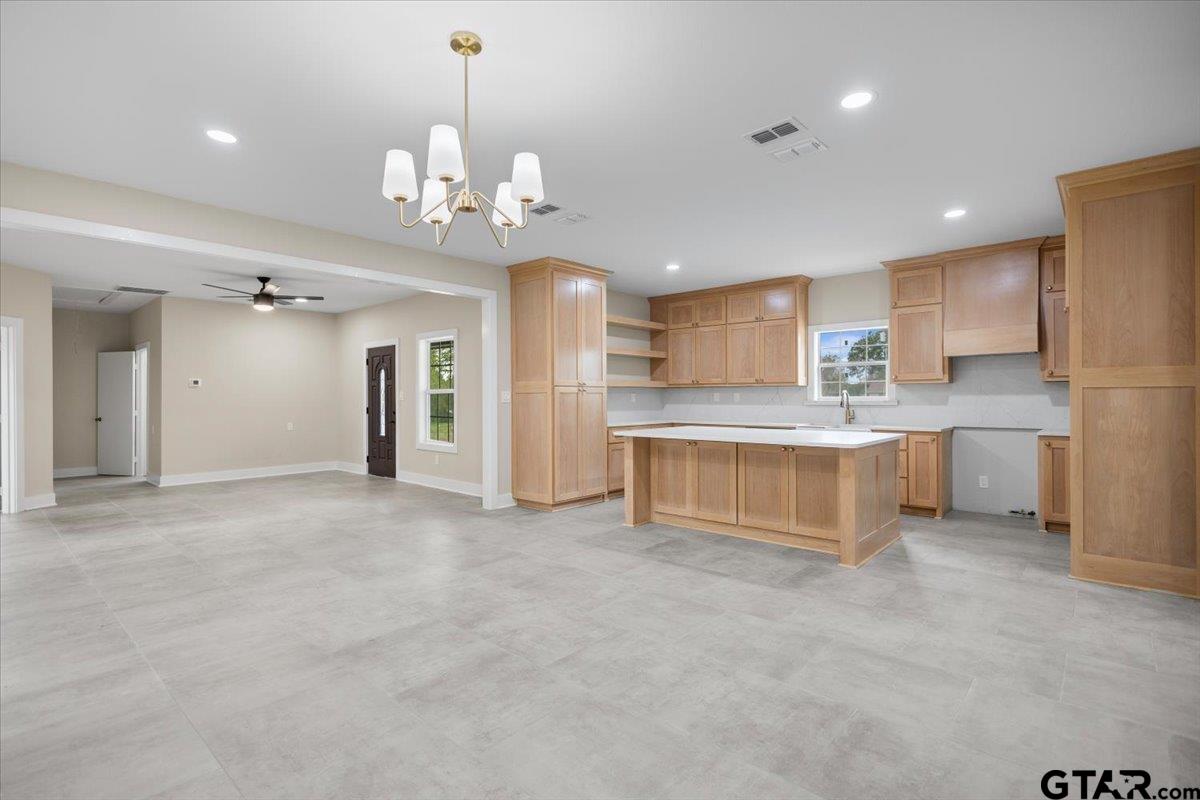 4123 County Road 1120 Tyler, TX 75704 - Photo 18 of 43 a large white kitchen with a refrigerator a sink dishwasher a stove and a dining table with wooden floor