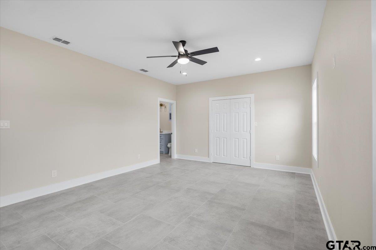 4123 County Road 1120 Tyler, TX 75704 - Photo 22 of 43 an empty room with a ceiling fan and a window