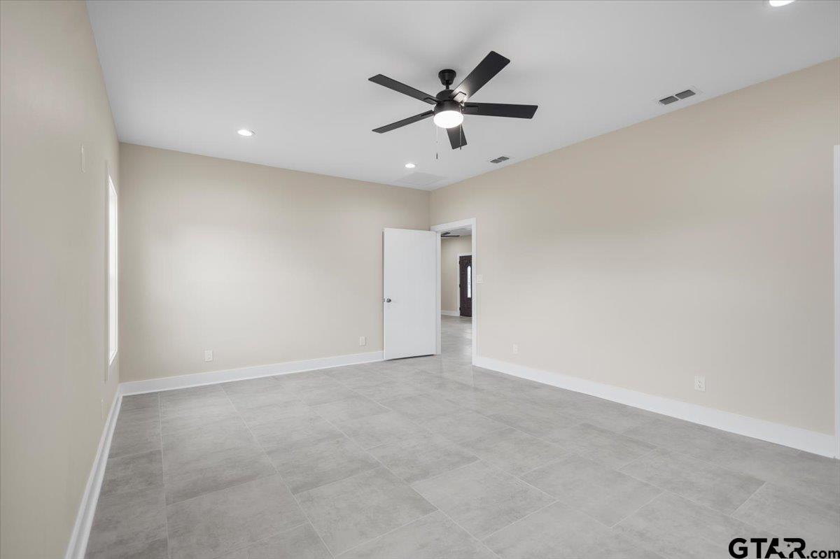 4123 County Road 1120 Tyler, TX 75704 - Photo 23 of 43 an empty room with a ceiling fan and window