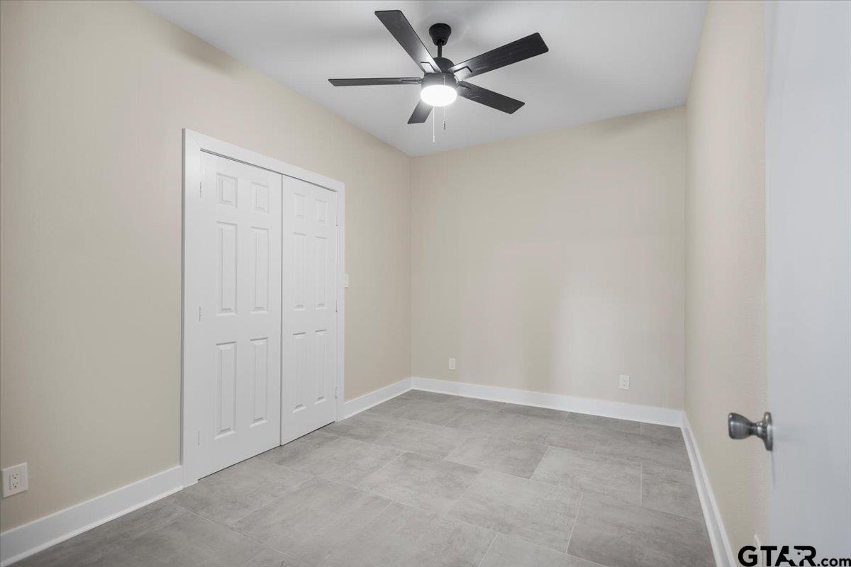 4123 County Road 1120 Tyler, TX 75704 - Photo 27 of 43 an empty room with a ceiling fan and a window