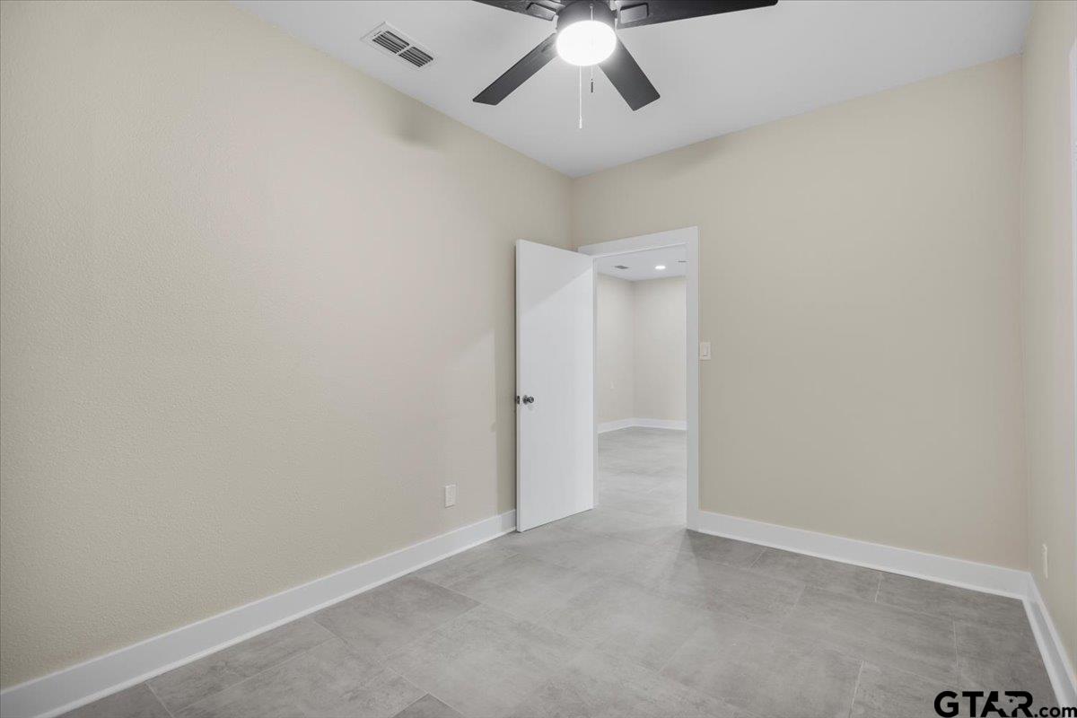 4123 County Road 1120 Tyler, TX 75704 - Photo 29 of 43 an empty room with a ceiling fan and a window