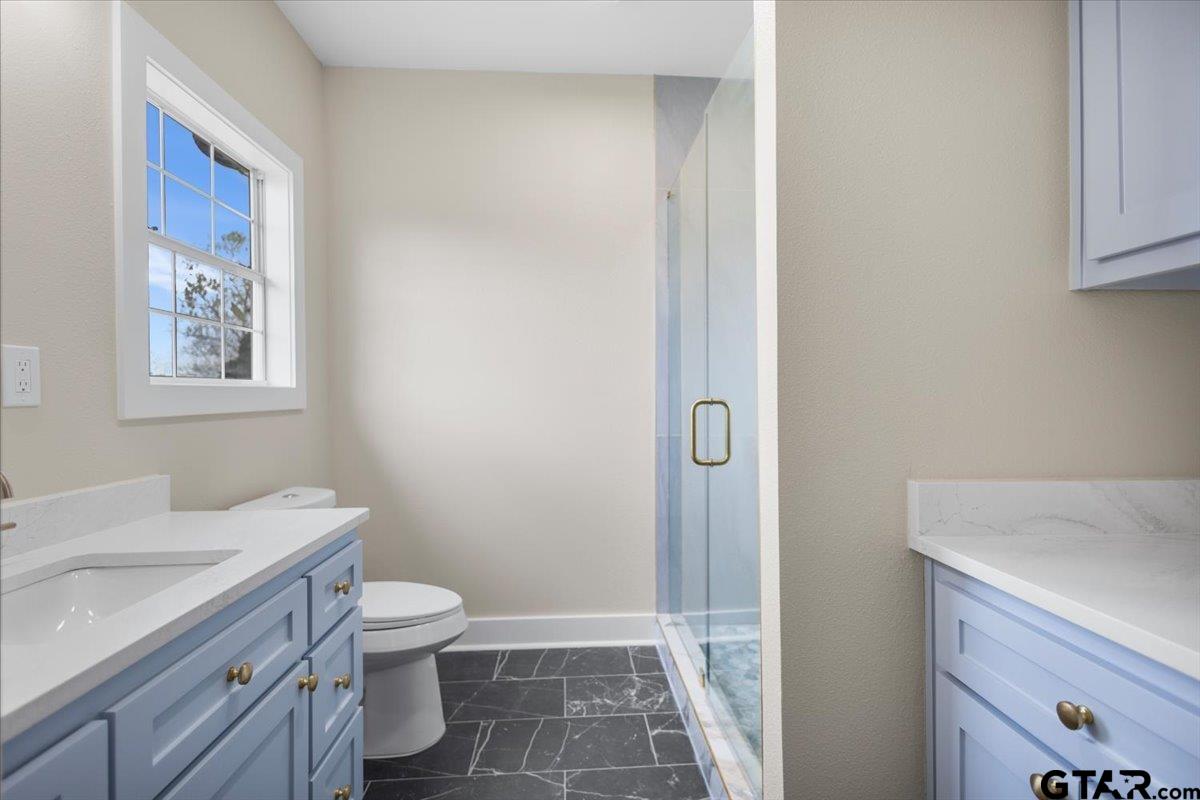4123 County Road 1120 Tyler, TX 75704 - Photo 32 of 43 a bathroom with a granite countertop sink toilet and shower
