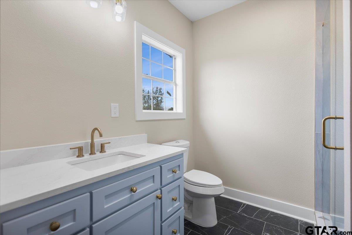 4123 County Road 1120 Tyler, TX 75704 - Photo 33 of 43 a bathroom with a toilet sink vanity and mirror