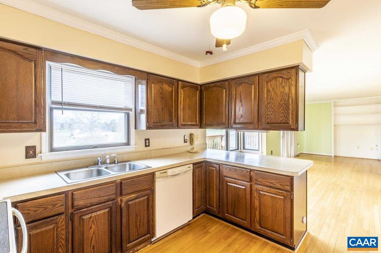 2011 Wilderness Road Reva, VA 22735 - Photo 34 of 75 a kitchen with granite countertop wooden cabinets a sink and dishwasher next to a window