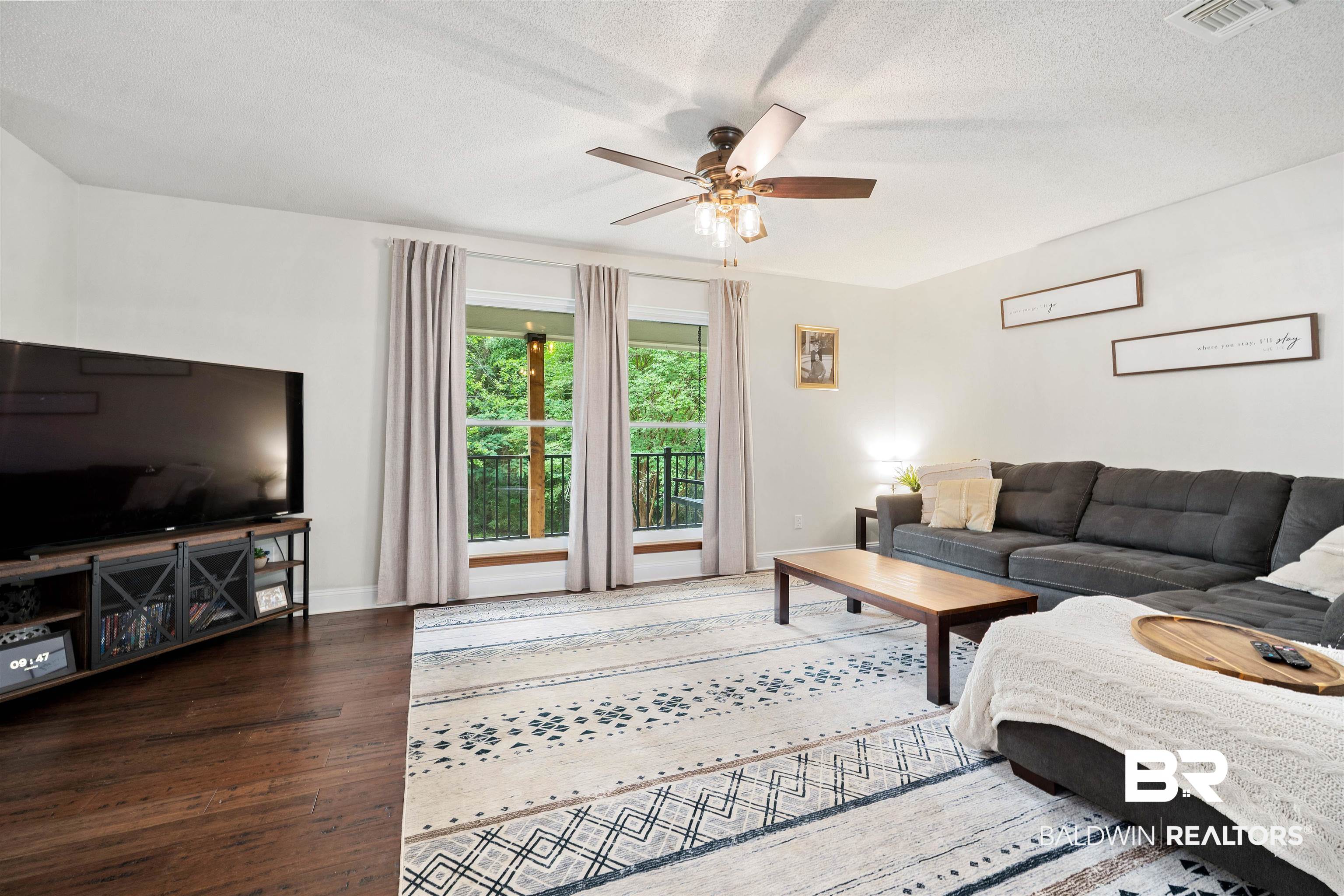 71 Caisson Trace Daphne, AL 36527 - Photo 6 of 36 Living room featuring wood-finish flooring, white walls, and a ceiling fan with integrated lighting