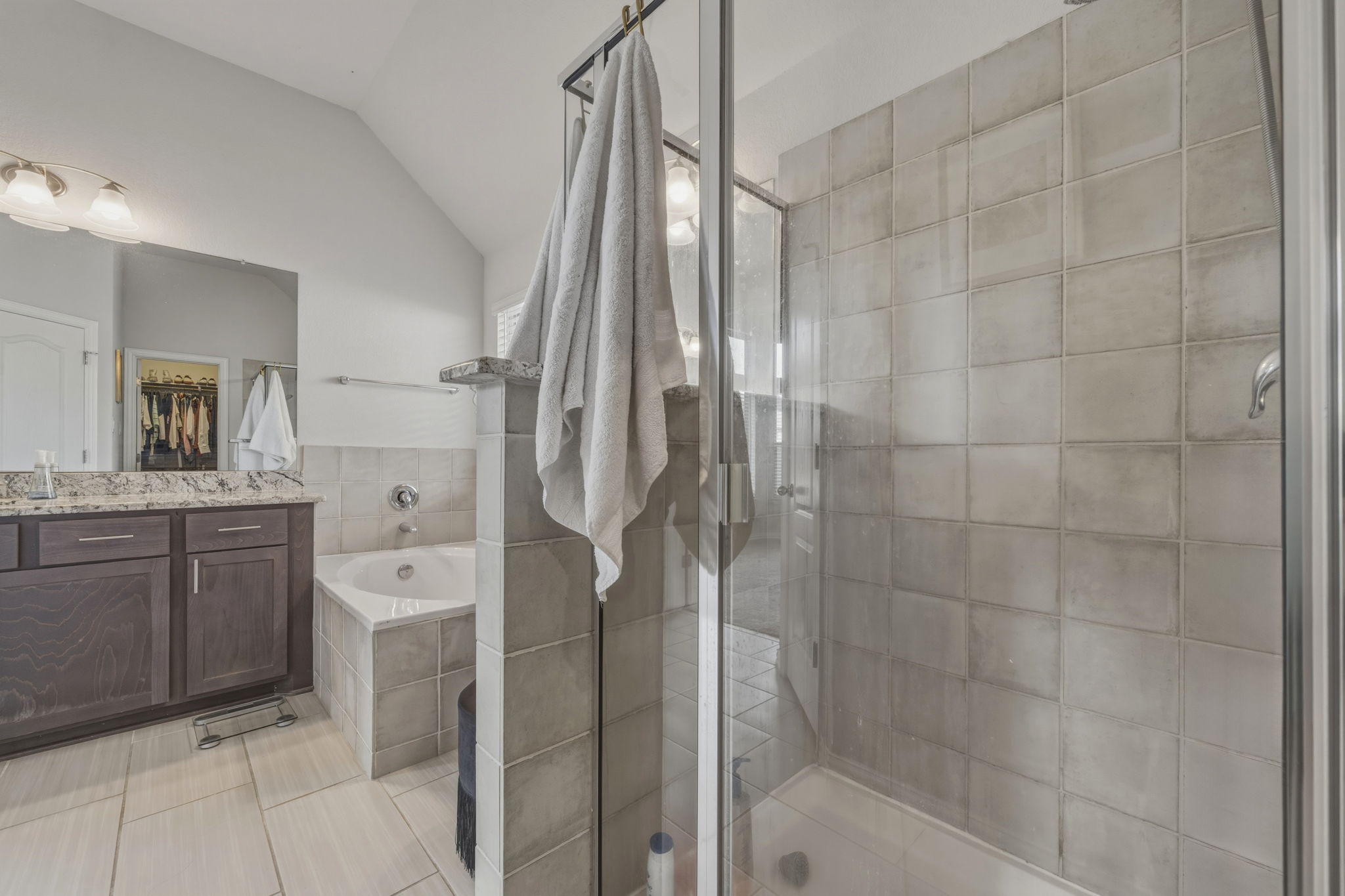 918 Leadtree Loop Buda, TX 78610 - Photo 17 of 27 Full bath with vaulted ceiling, a garden tub, vanity, a stall shower, and light tile patterned floors