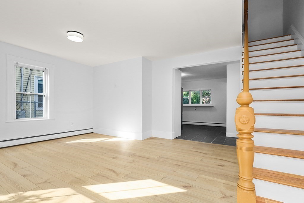 27 Ladd Street, Unit 27 Watertown, MA 02472 - Photo 4 of 10 a view of an empty room with wooden floor and a window