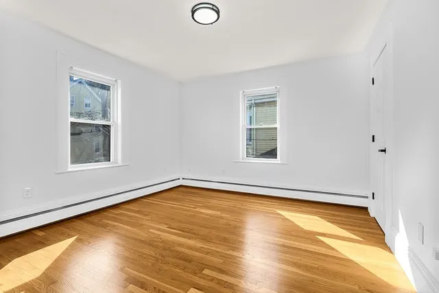 a view of a room with wooden floor and white walls