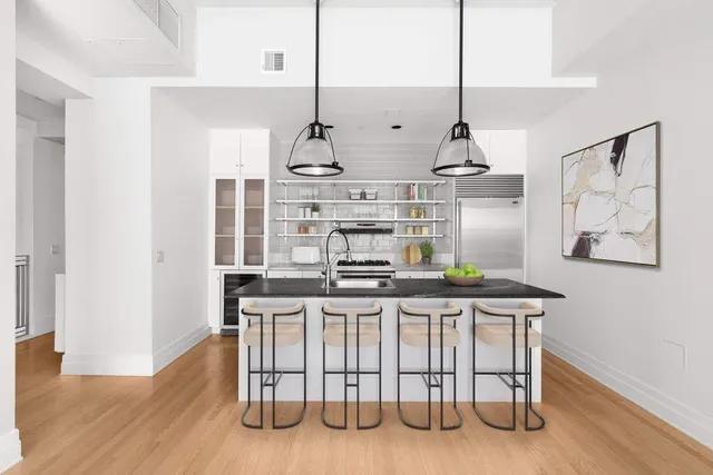 a living room with furniture a flat screen tv and kitchen view
