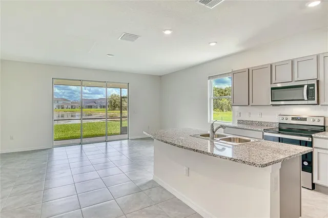 a kitchen with a sink a counter top space cabinets and stainless steel appliances