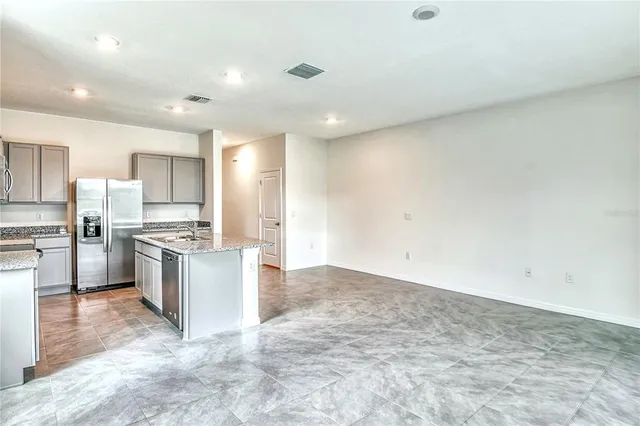 a kitchen with a refrigerator and a stove top oven